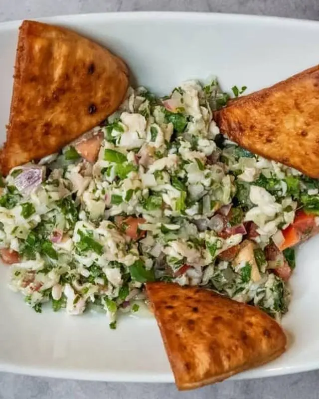 Seafood-forward plated salad with triangular crisp