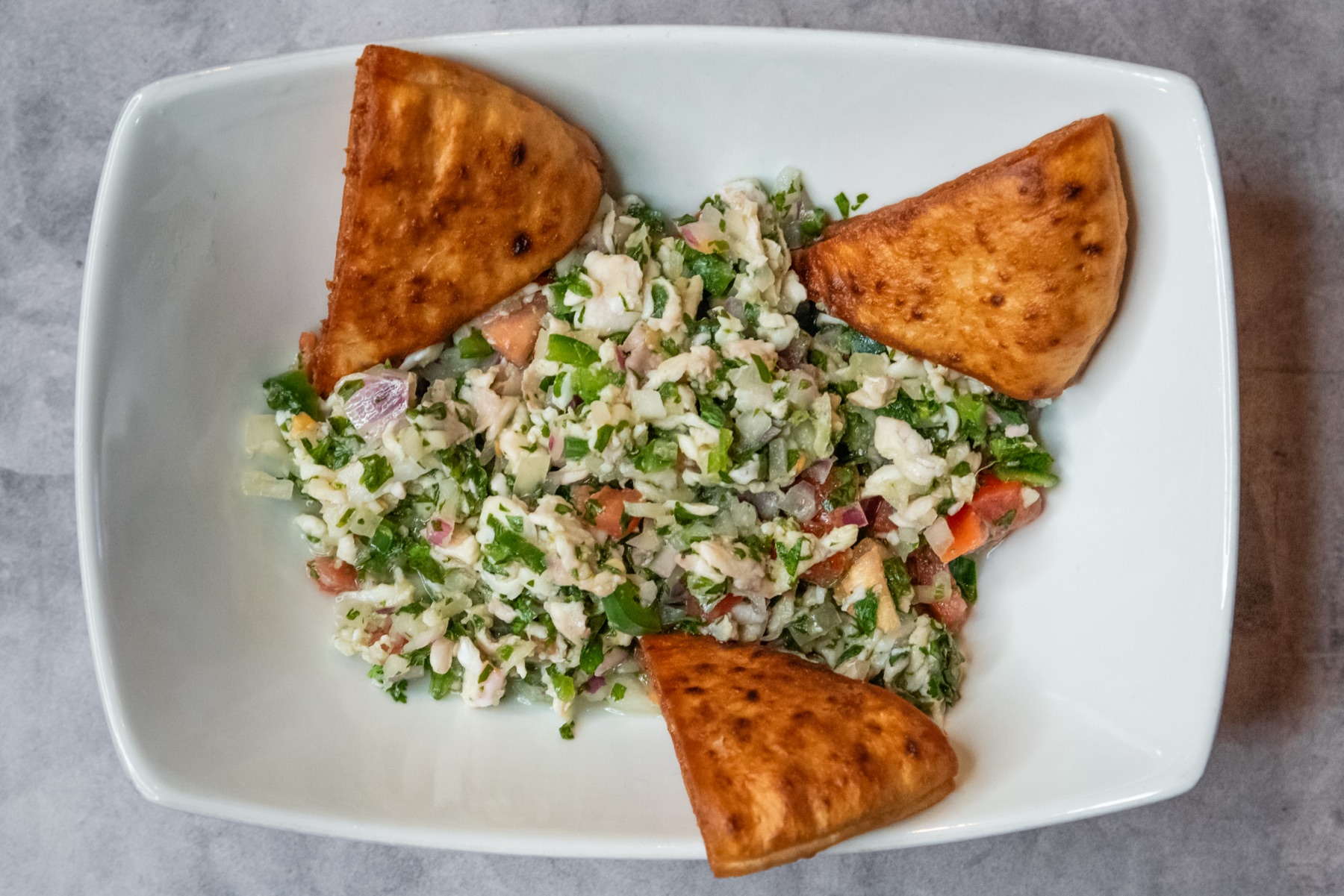 Seafood-forward plated salad with triangular crisp