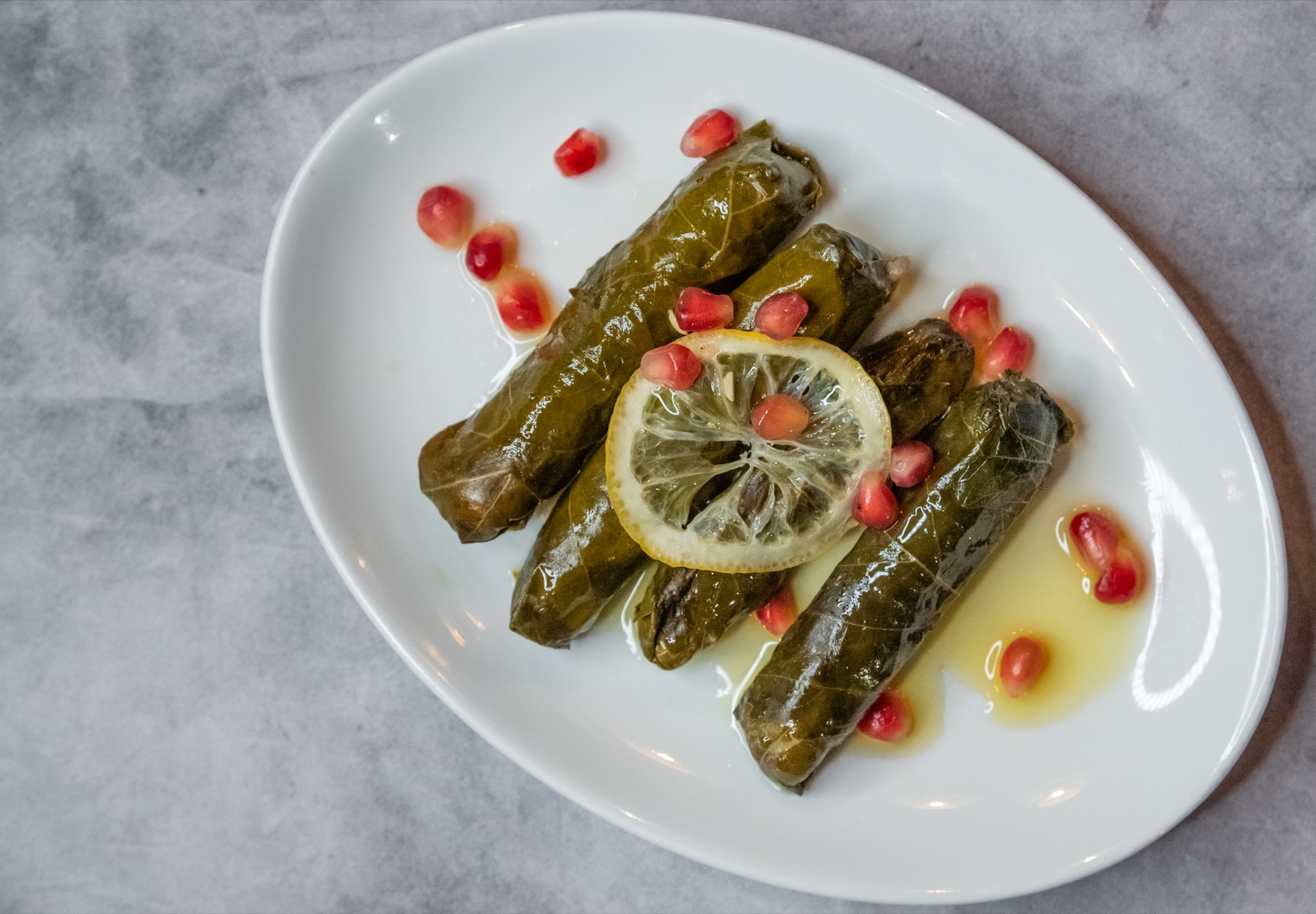 Stuffed vine leaves plated with lemon and oil