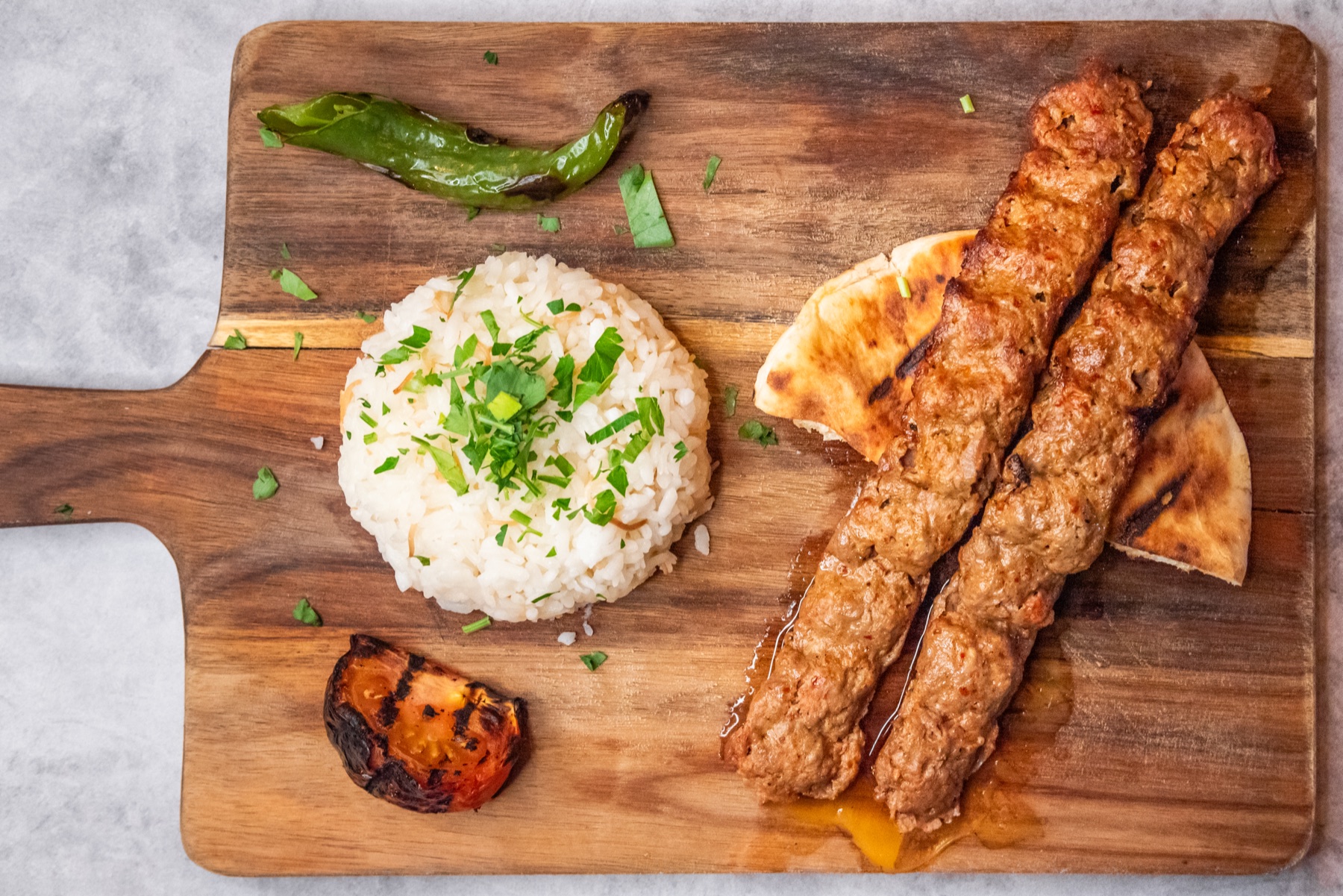 Skewers plated with rice and charred vegetables