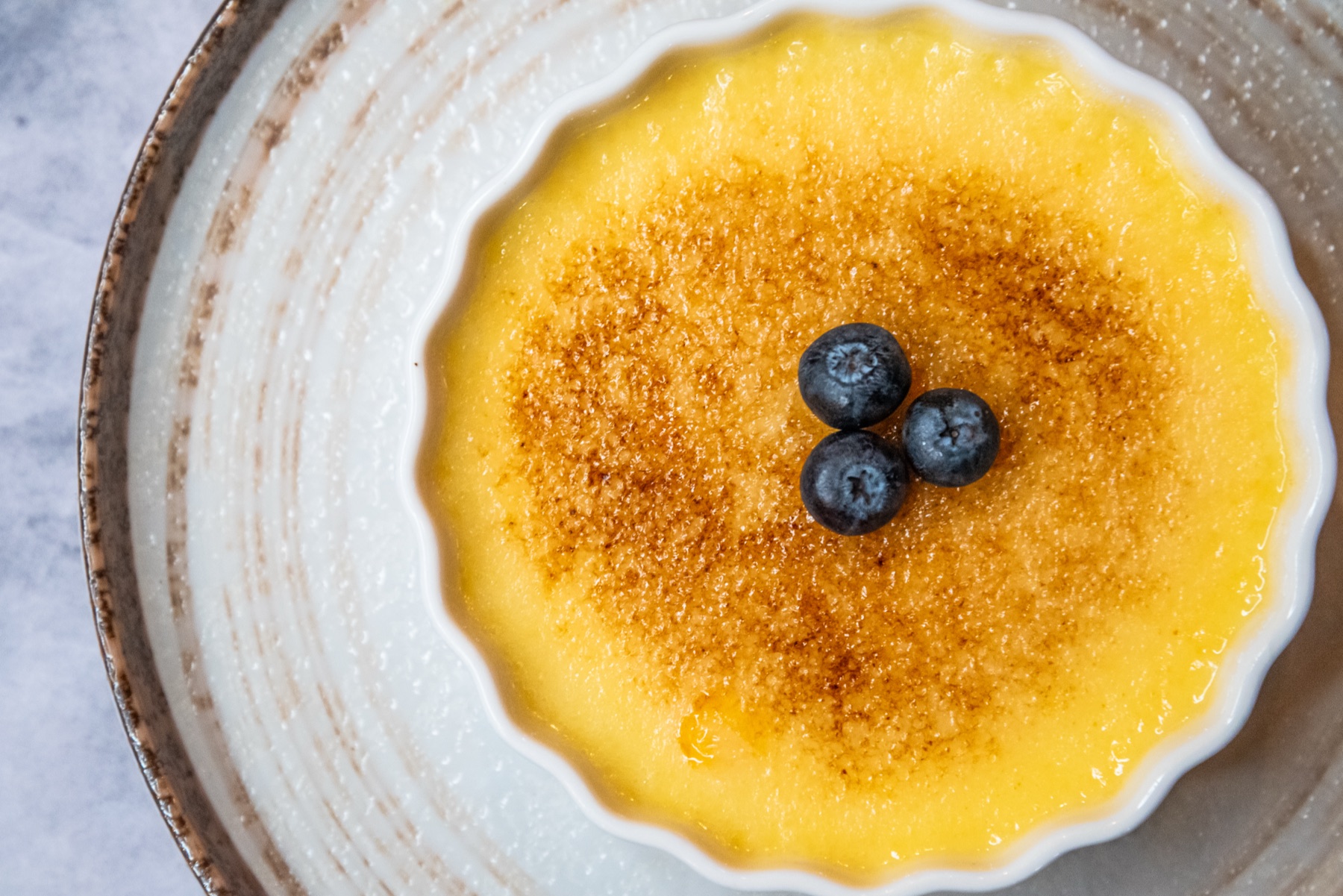 Bruleed dessert topped with blueberries