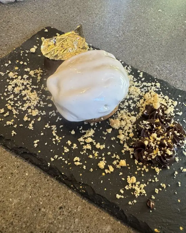 White glazed dessert sphere with gold leaf on slate