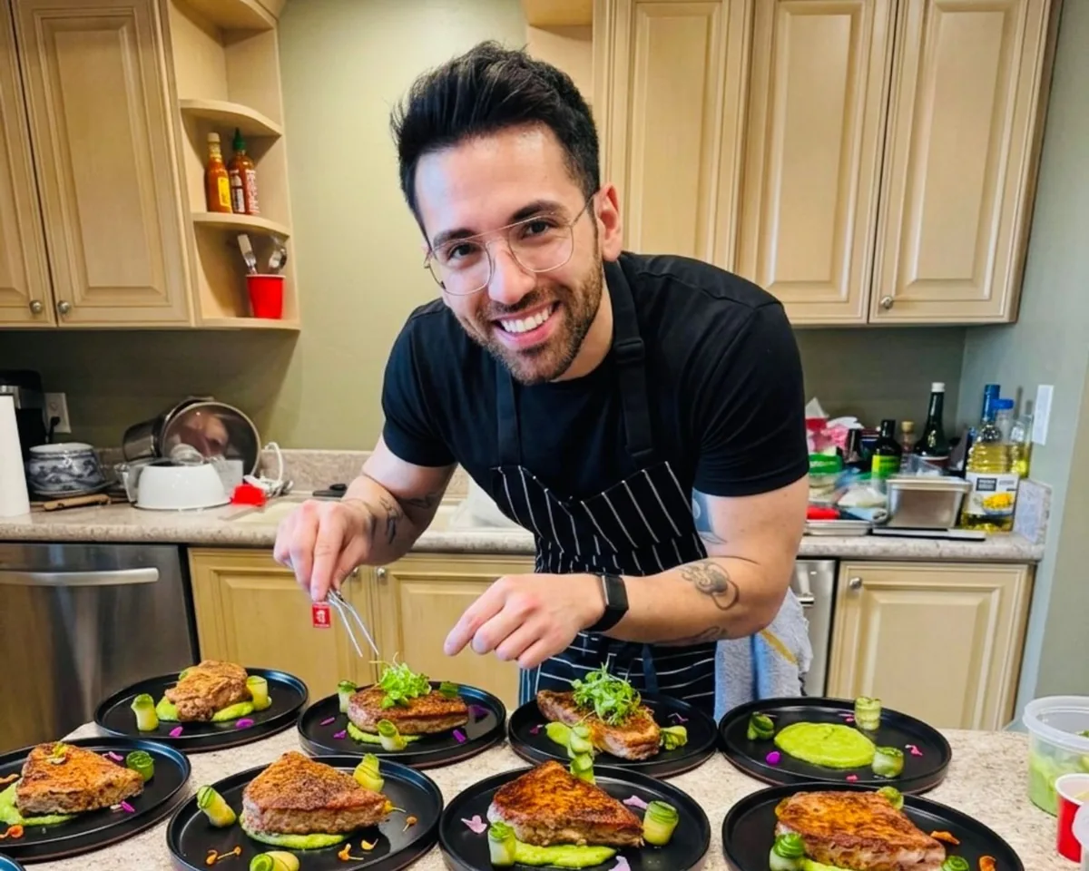 Chef Fikret Siler smiling at the camera while plating on-site dinner courses