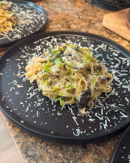Creamy mushroom pasta with grated cheese on black plates
